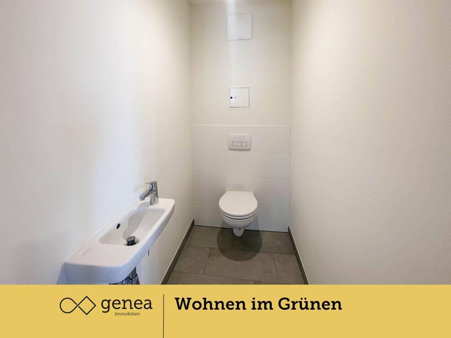 Modernes Gäste-WC mit wandhängender Toilette, kleinem Waschbecken und Fliesenboden.