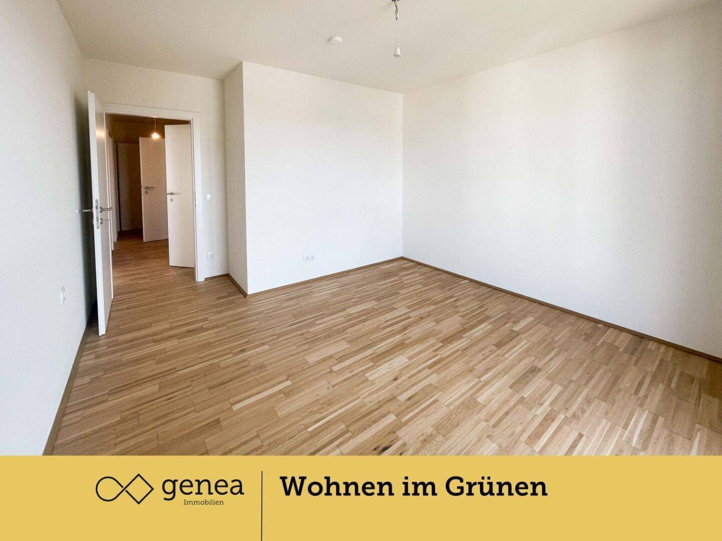 Helles Schlafzimmer mit Parkettboden und weißen Wänden, das einen Zugang zum Flur bietet.