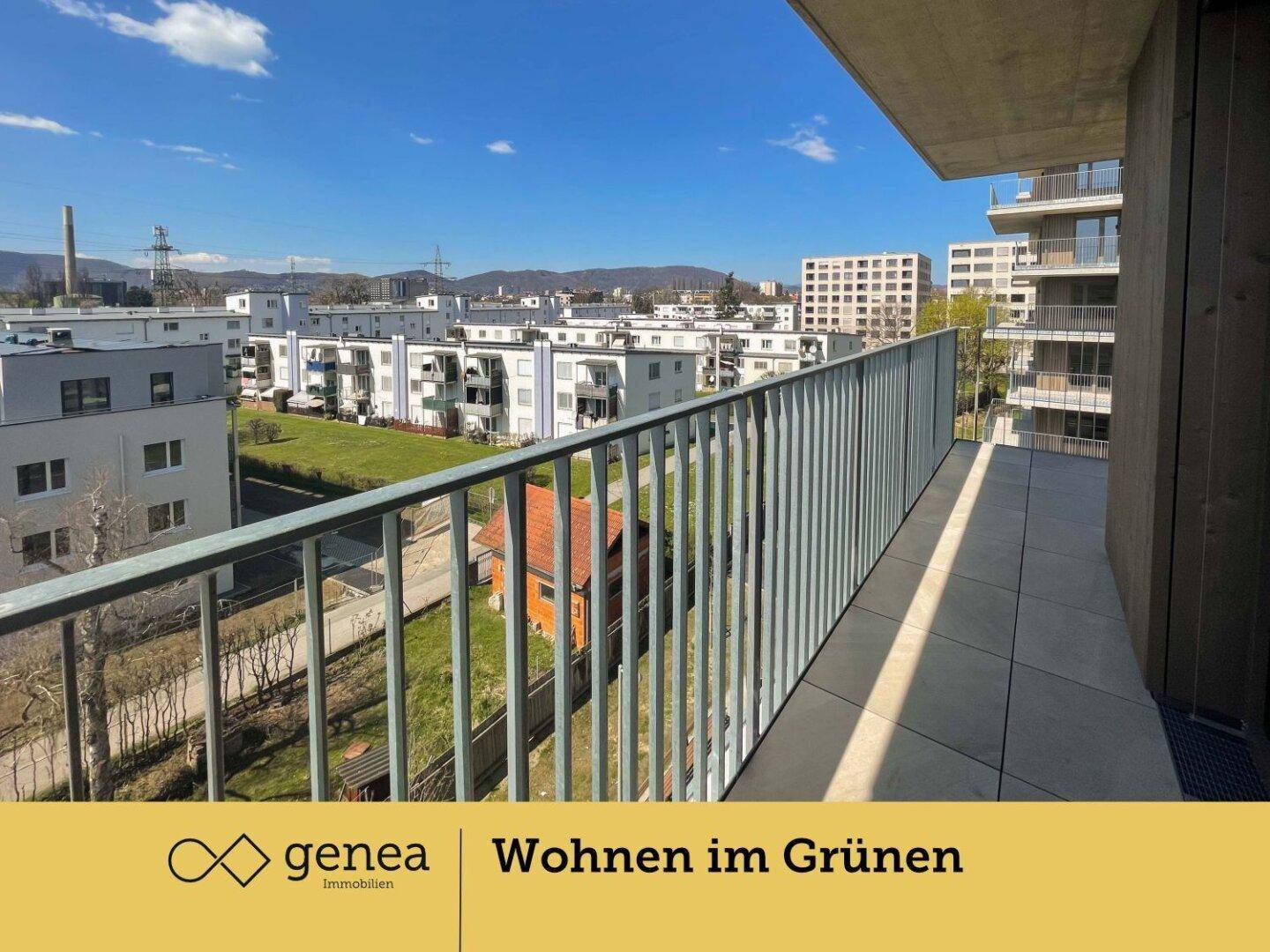 Großer Balkon mit Fliesenboden und weitem Blick über die moderne Wohnsiedlung.
