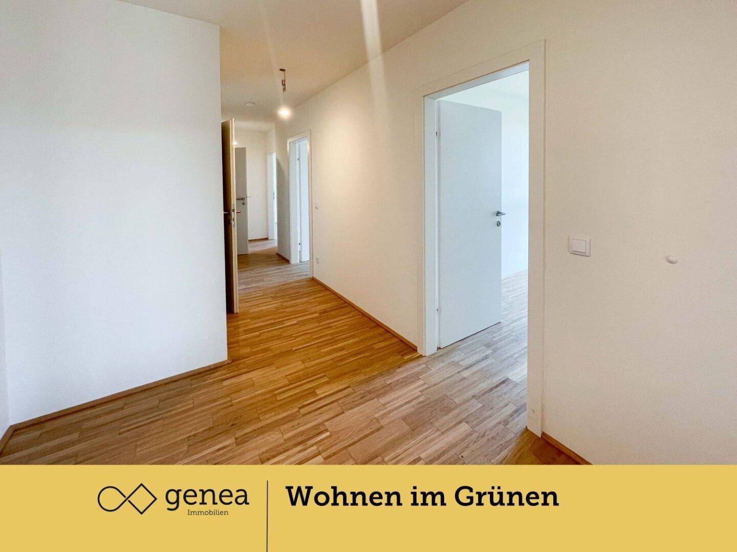 Heller Flur mit Holzparkettboden und Zugang zu mehreren Zimmern.