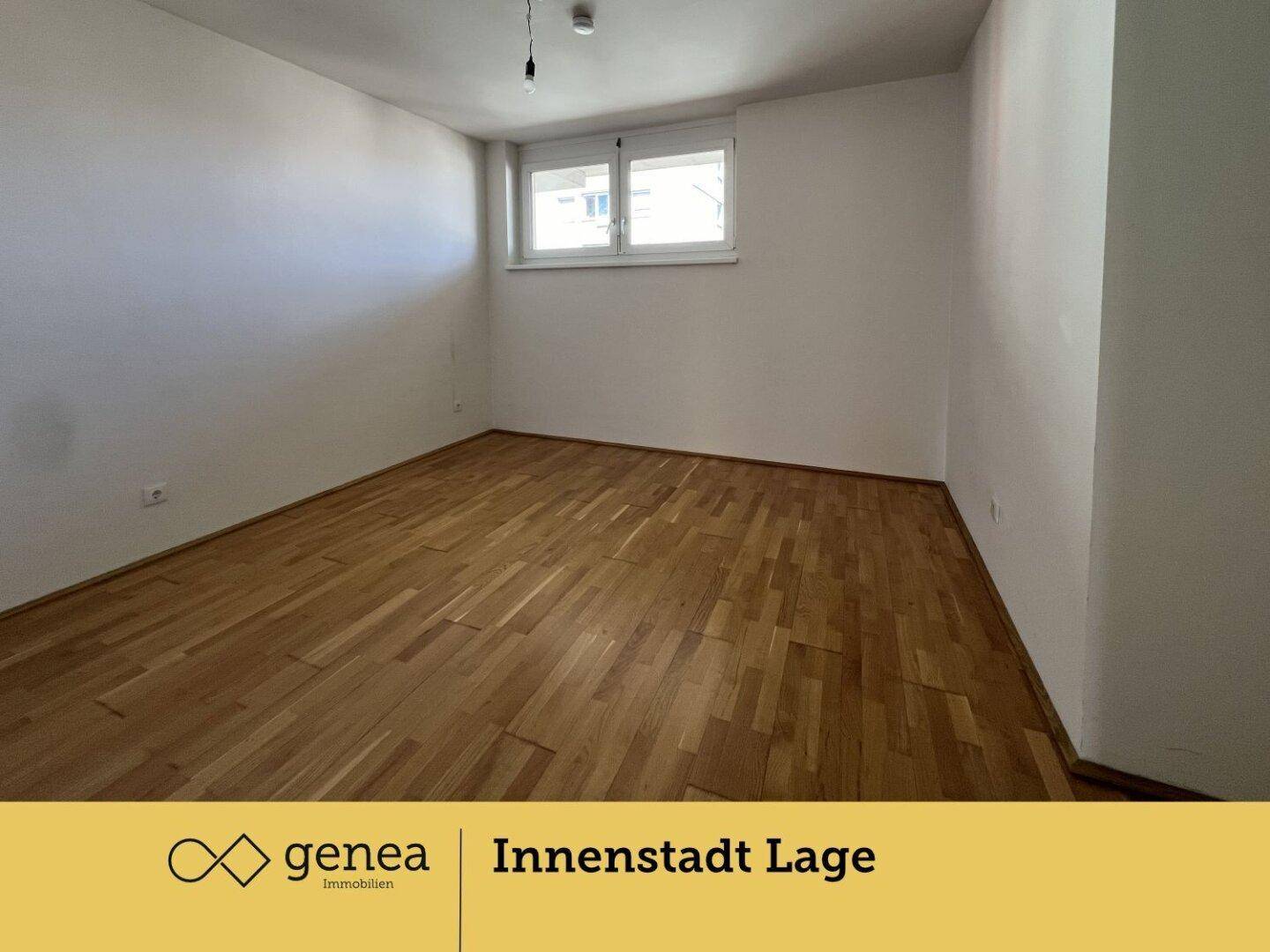 Helles, leeres Zimmer mit Holzboden und einem Fenster, ideal als Schlaf- oder Arbeitszimmer.