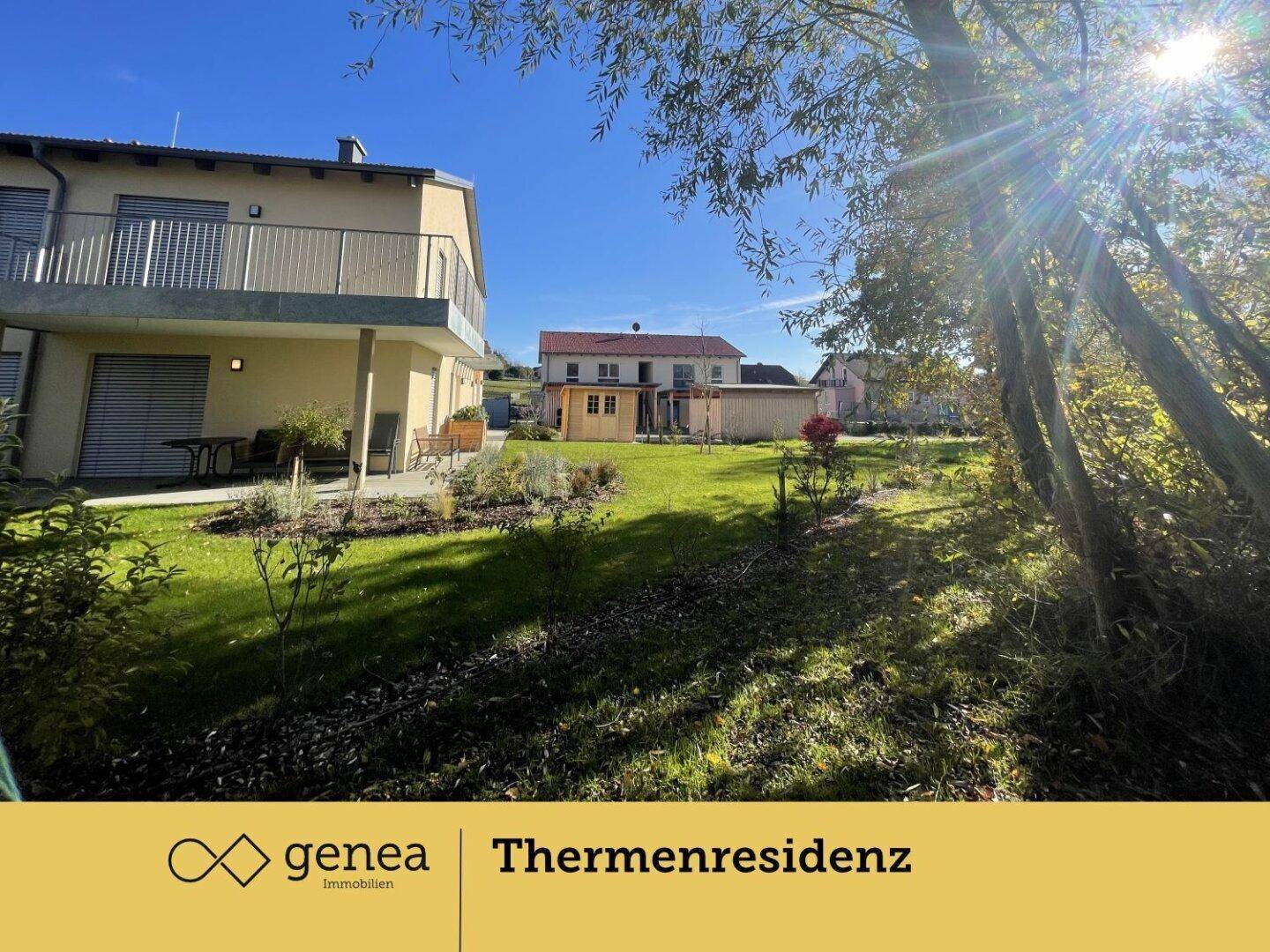 Sonniger Gartenbereich mit Rasenfläche und Blick auf die Doppelhaushälfte.