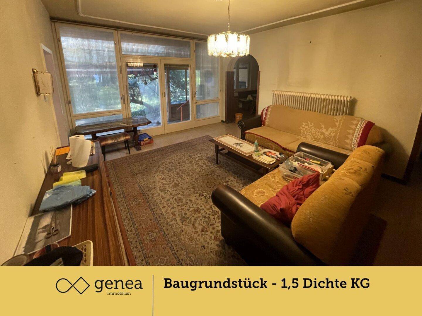 Gemütliches Wohnzimmer mit Sofas, einem Teppich und Zugang zu einem verglasten Wintergarten, der viel Licht hereinlässt.