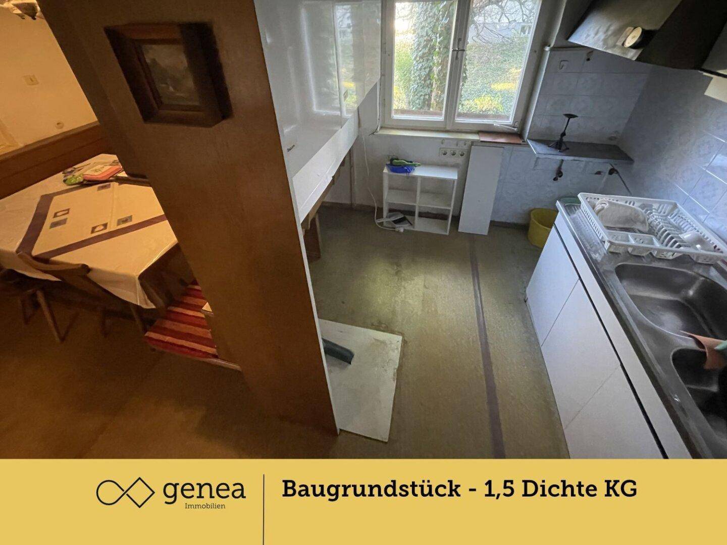 Einfache Küche mit Spülbecken, Unterschränken und einem Fenster, das den Blick ins Grüne freigibt.