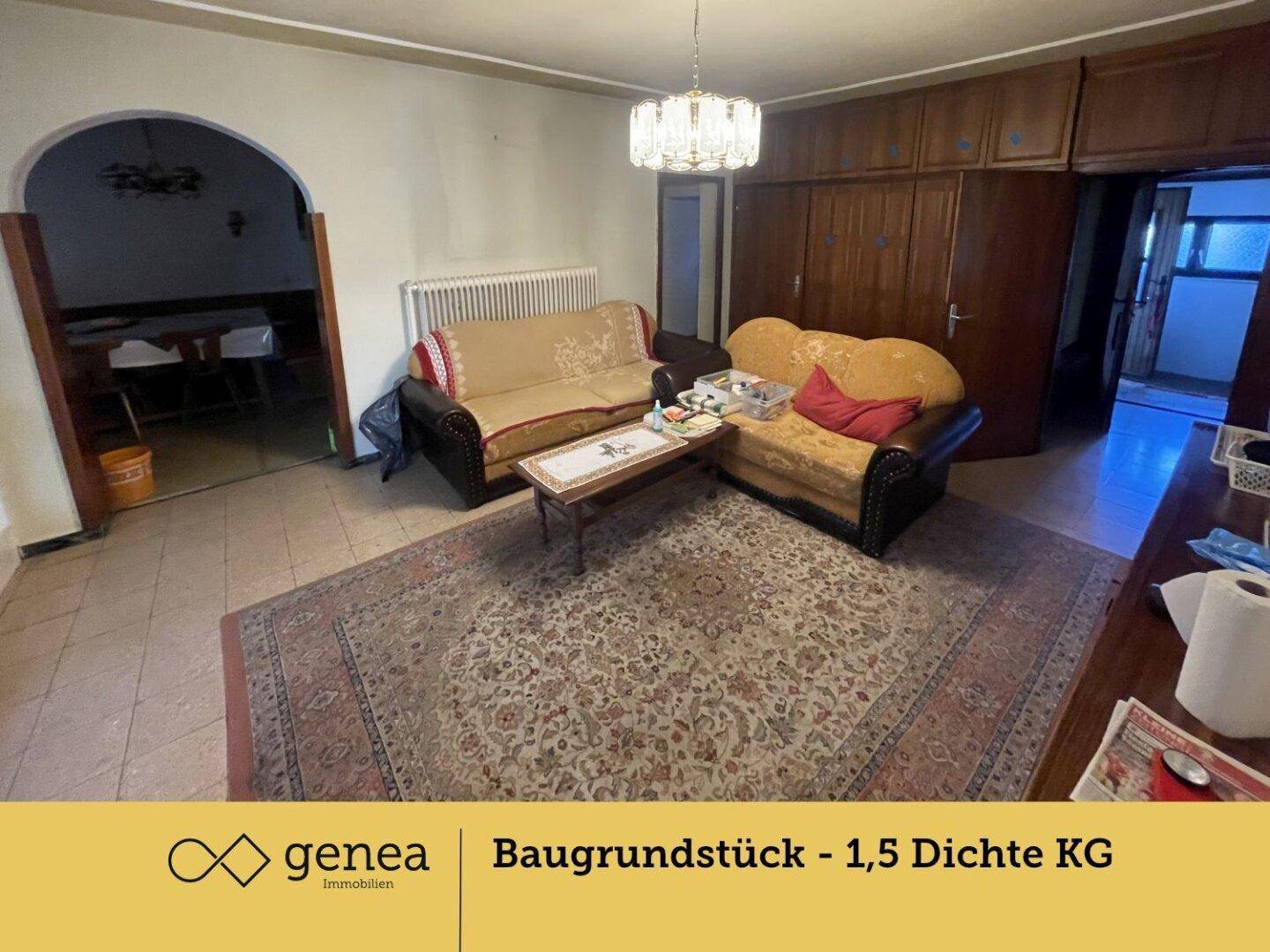 Gemütliches Wohnzimmer mit Sofas, einem Teppich und Zugang zu einem verglasten Wintergarten, der viel Licht hereinlässt.