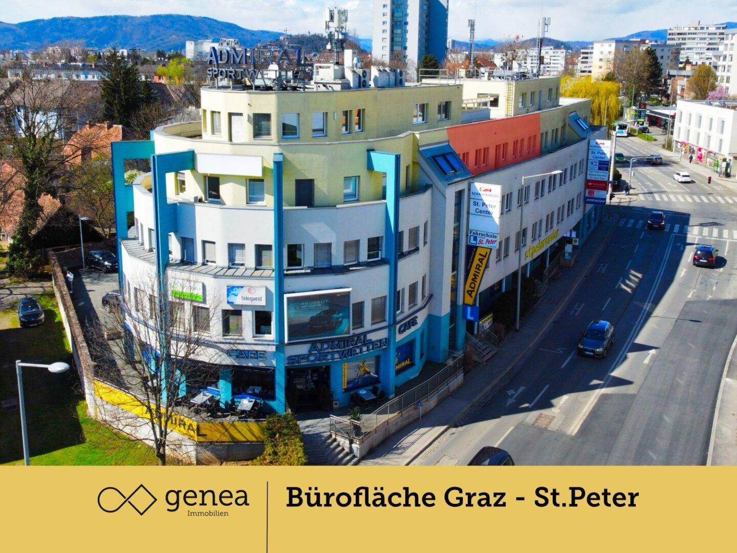 Weitläufige Luftaufnahme des Bürogebäudes und der umliegenden Stadtlandschaft mit Straßen und Verkehr.