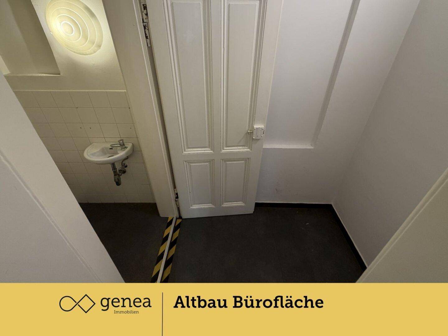 Kleiner Toilettenraum mit Waschbecken und weißen Fliesen an der Wand.