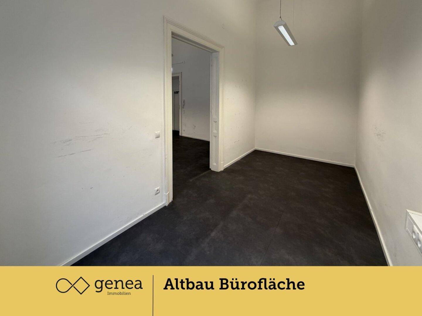 Leerer Büroraum mit dunklem Boden und weißen Wänden, bereit zur individuellen Gestaltung.