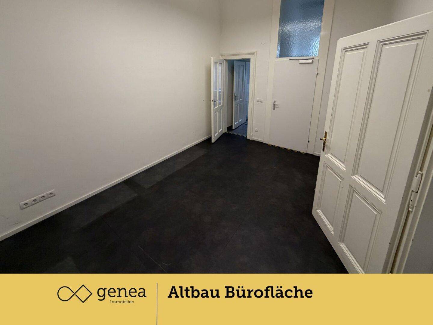 Leerer Büroraum mit hohen Decken, weißen Wänden und dunklem Bodenbelag, bereit für neue Mieter.