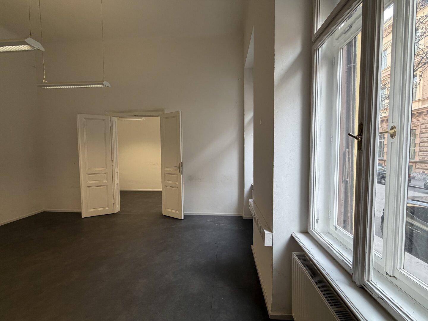 Heller Büroraum mit Blick aus dem Fenster auf die umliegenden Gebäude.