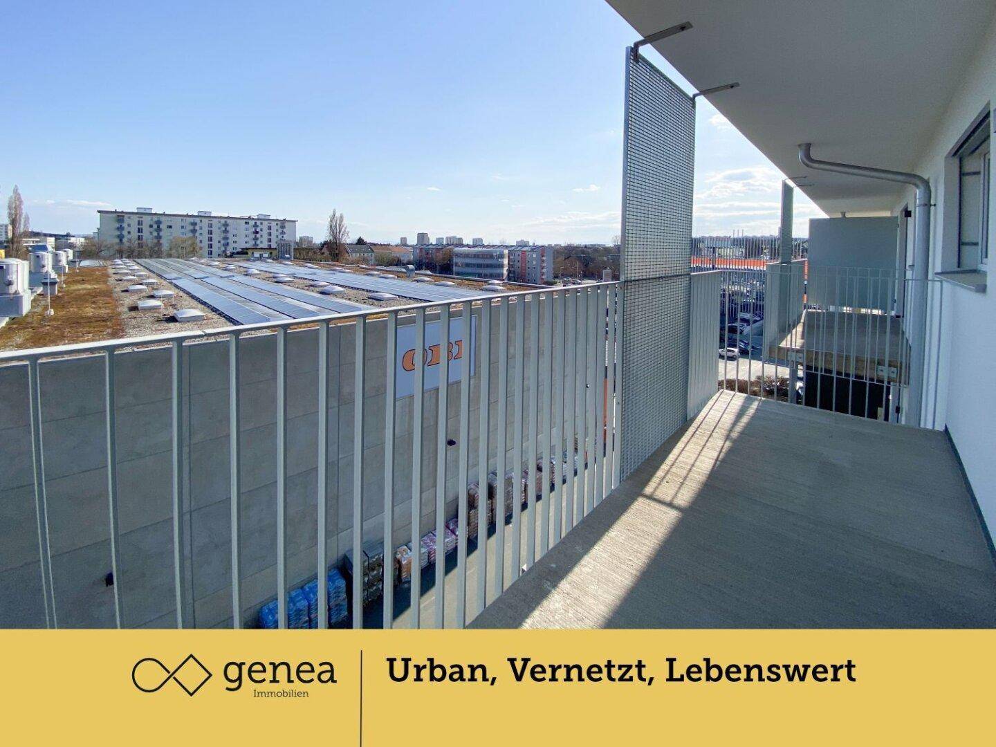 Balkon mit Metallgeländer und weitem Blick über die Dächer und Solaranlagen der Umgebung.