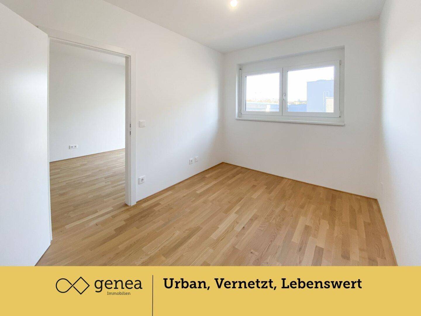 Helles Schlafzimmer mit Parkettboden und großem Fenster, bietet viel Tageslicht.
