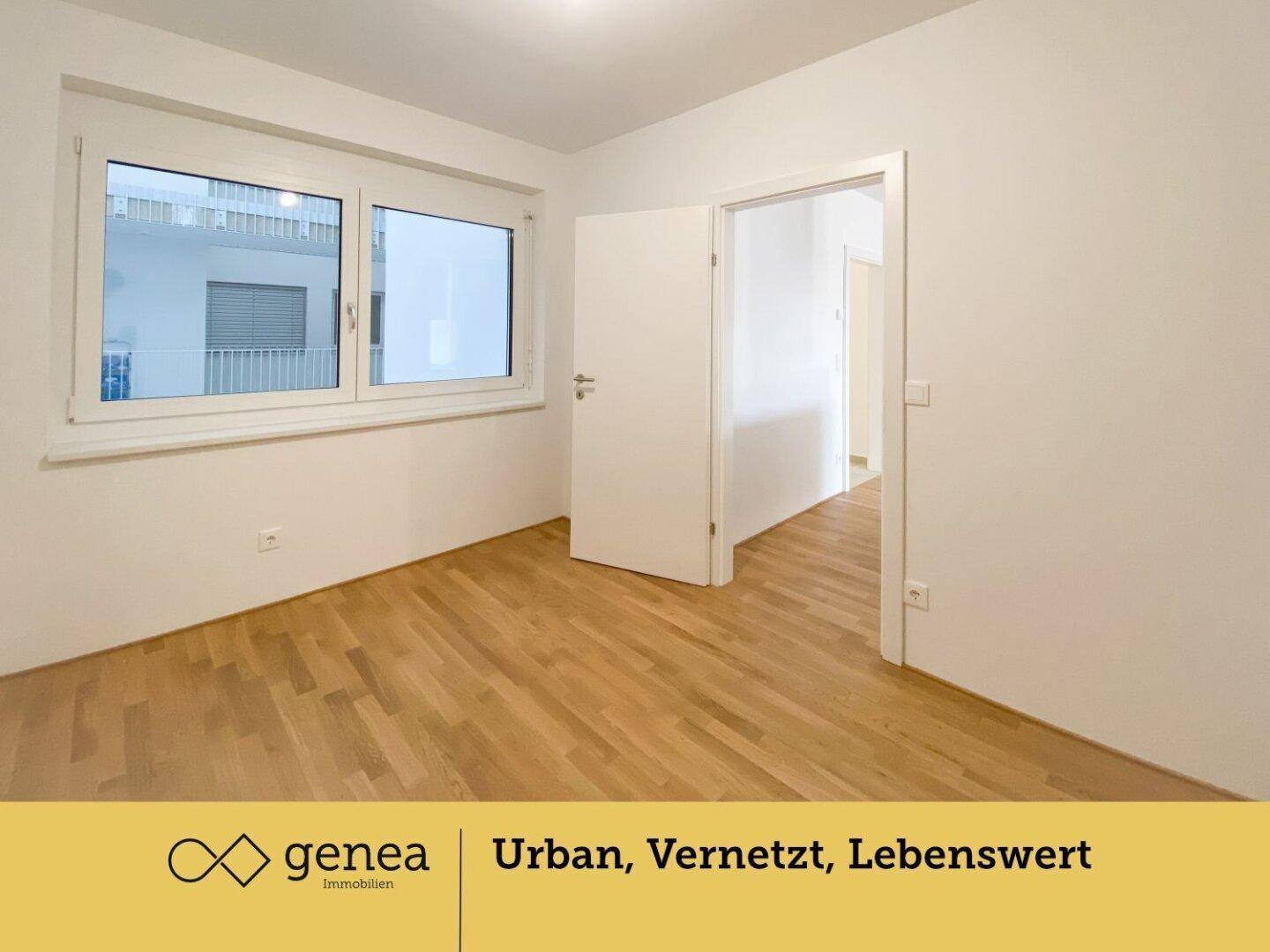 Helles Zimmer mit Parkettboden und großem Fenster, das viel Tageslicht hereinlässt.