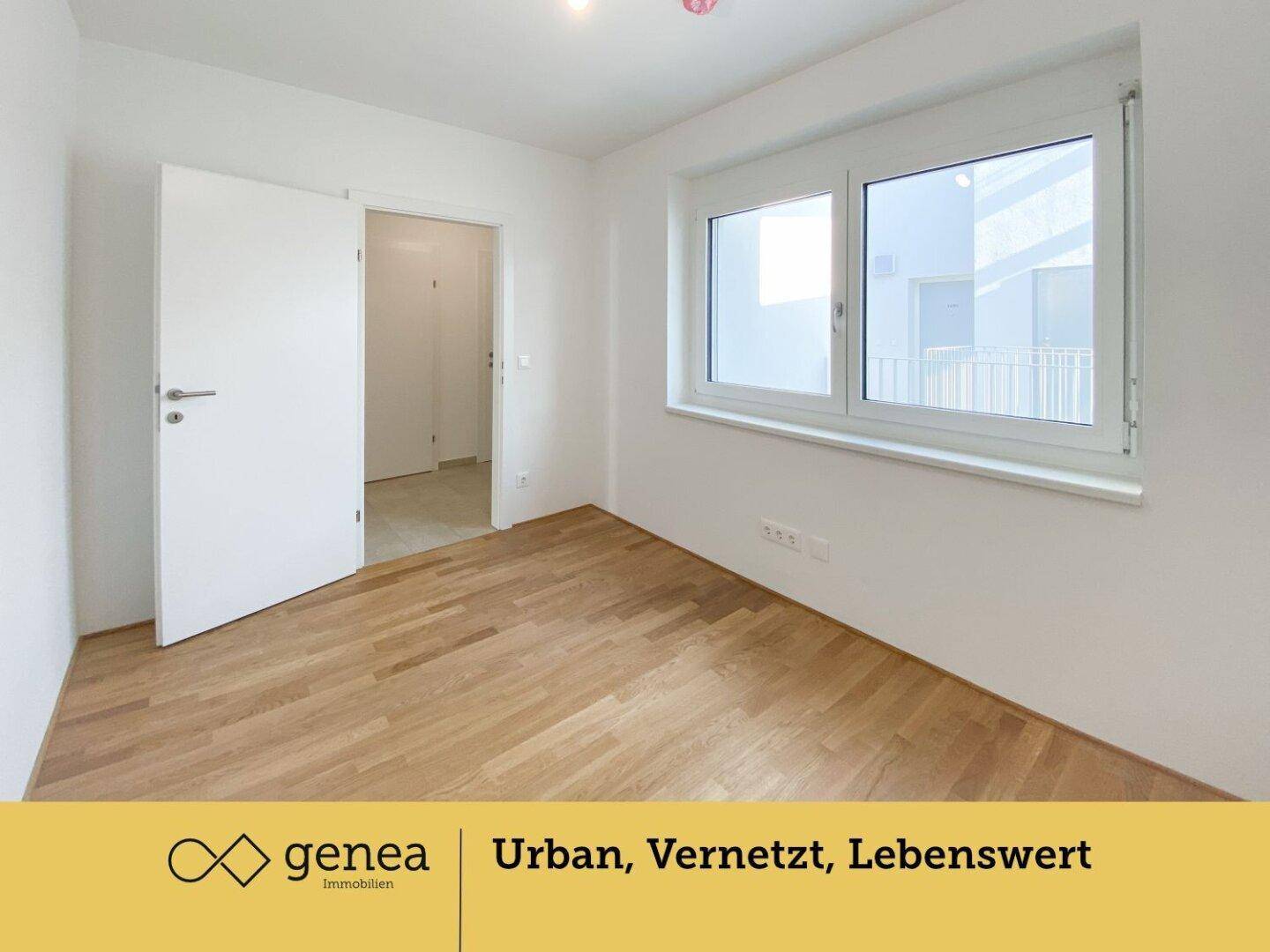 Helles Schlafzimmer mit Parkettboden und großem Fenster, das viel Tageslicht hereinlässt.