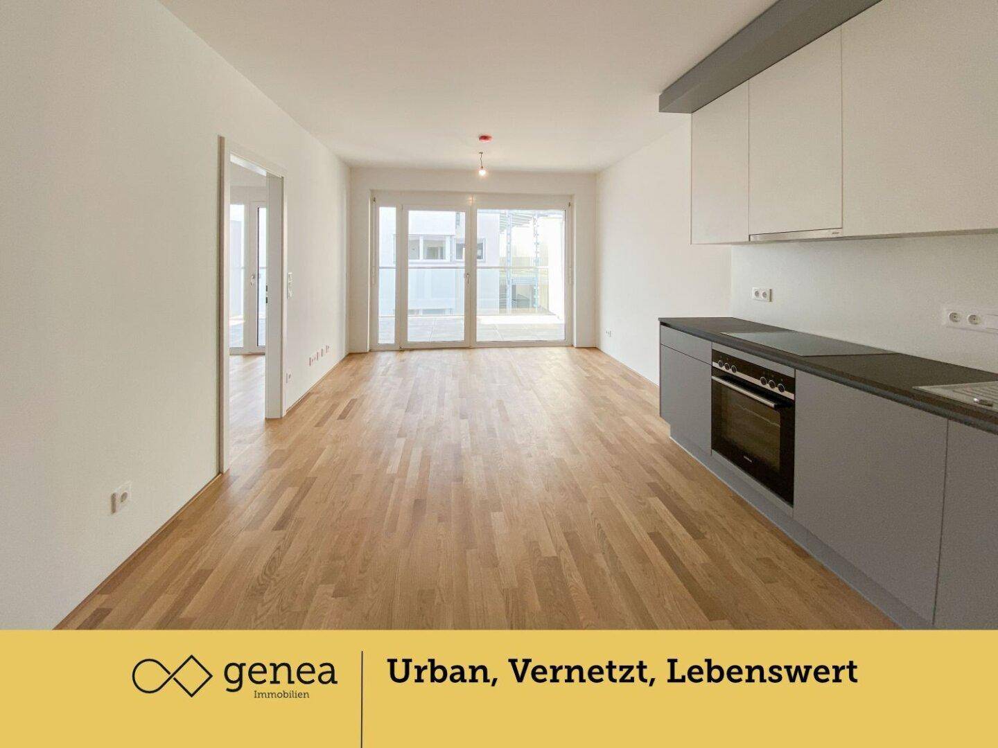 Offener Wohnbereich mit integrierter Küche, Parkettboden und Zugang zur Terrasse.