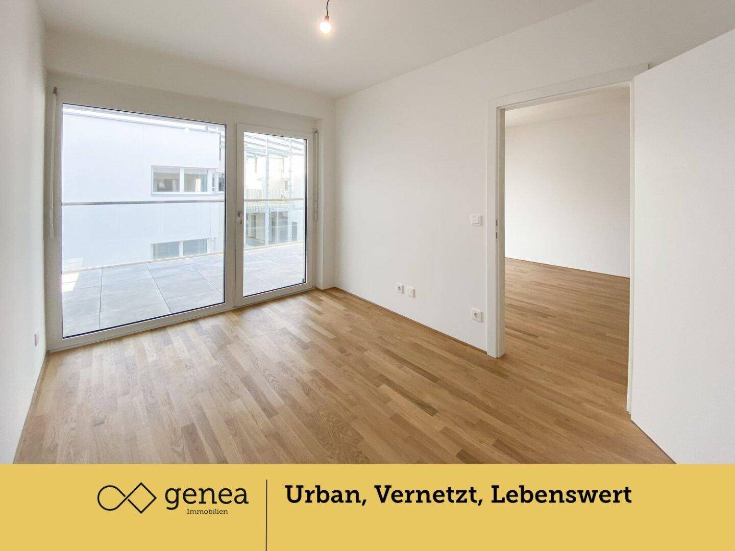 Heller Raum mit Parkettboden und großen Fenstern, die Zugang zur Terrasse bieten.