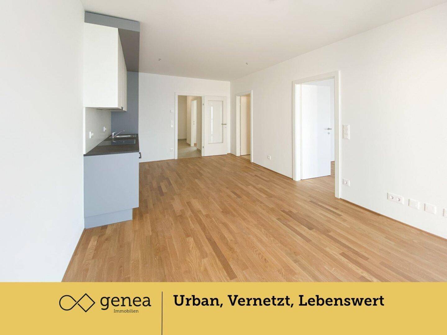 Geräumiger offener Wohnbereich mit integrierter Küche und hellem Parkettboden.