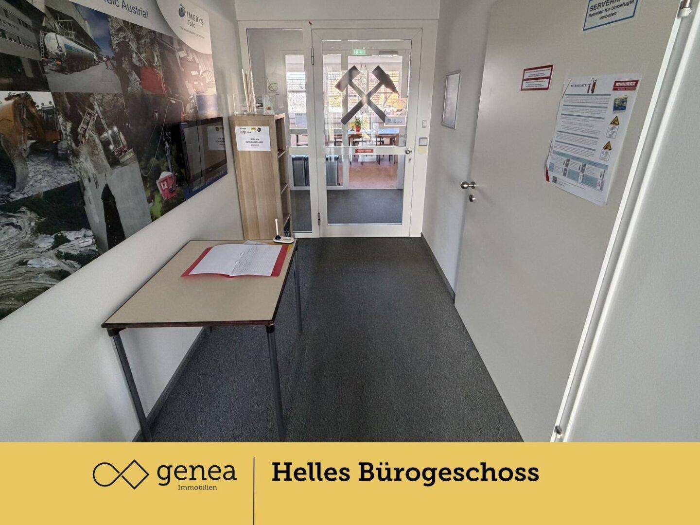 Heller Flur mit Teppichboden und einem kleinen Empfangstisch, der zu weiteren Büroräumen führt.