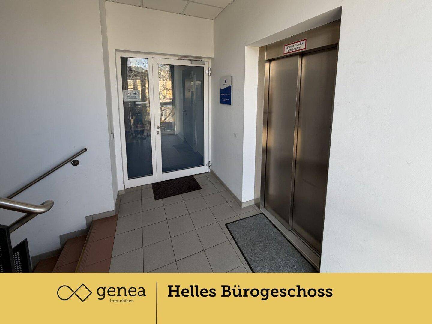 Eingangsbereich mit Fliesenboden, Glastür und einem modernen Aufzug, der Zugang zu den oberen Etagen bietet.