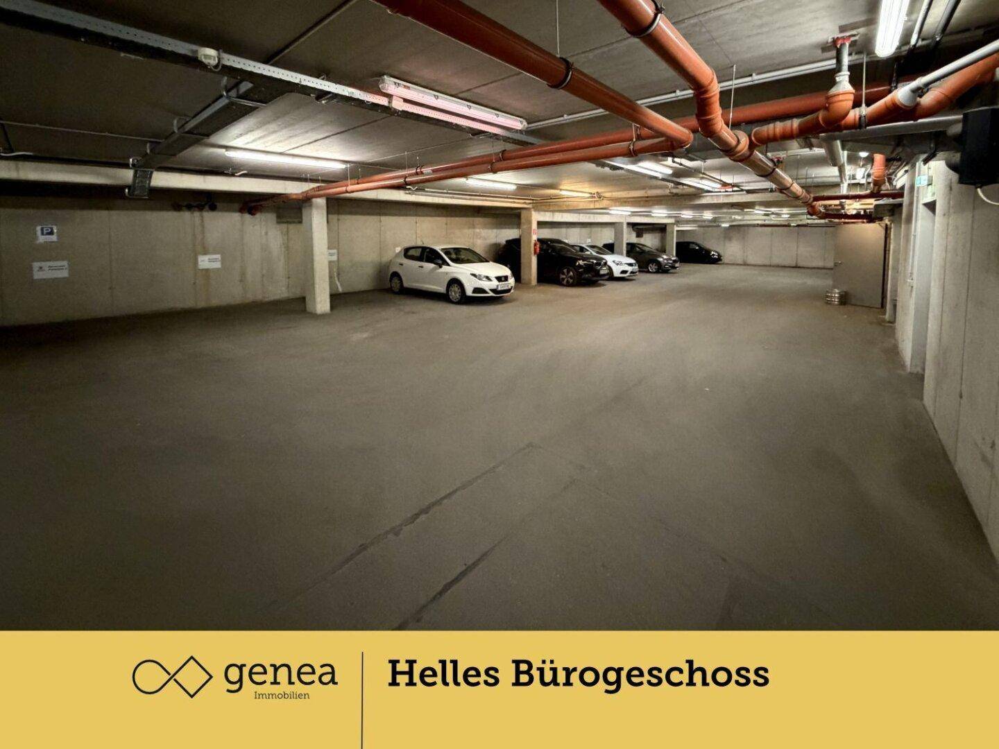 Tiefgarage mit mehreren geparkten Autos, Betonboden und sichtbaren Rohren an der Decke.