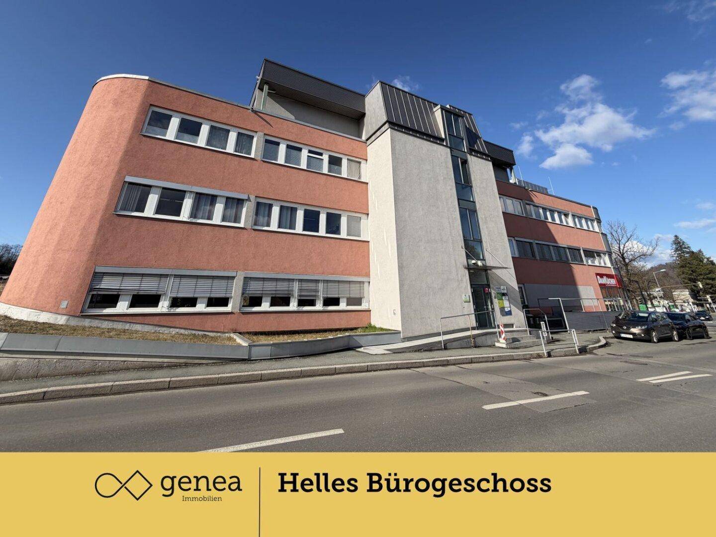 Ansicht der Gebäudeseite mit roter Fassade und horizontalen Fensterbändern, die sich entlang der Straße erstreckt.