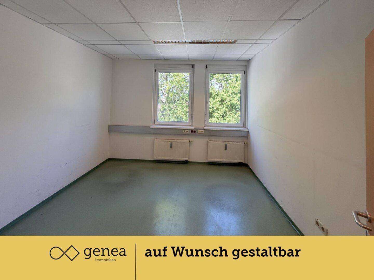 Geräumiger Büroraum mit viel Tageslicht, grünem Boden und weiß gestrichenen Wänden, ideal für Arbeitsbereiche.