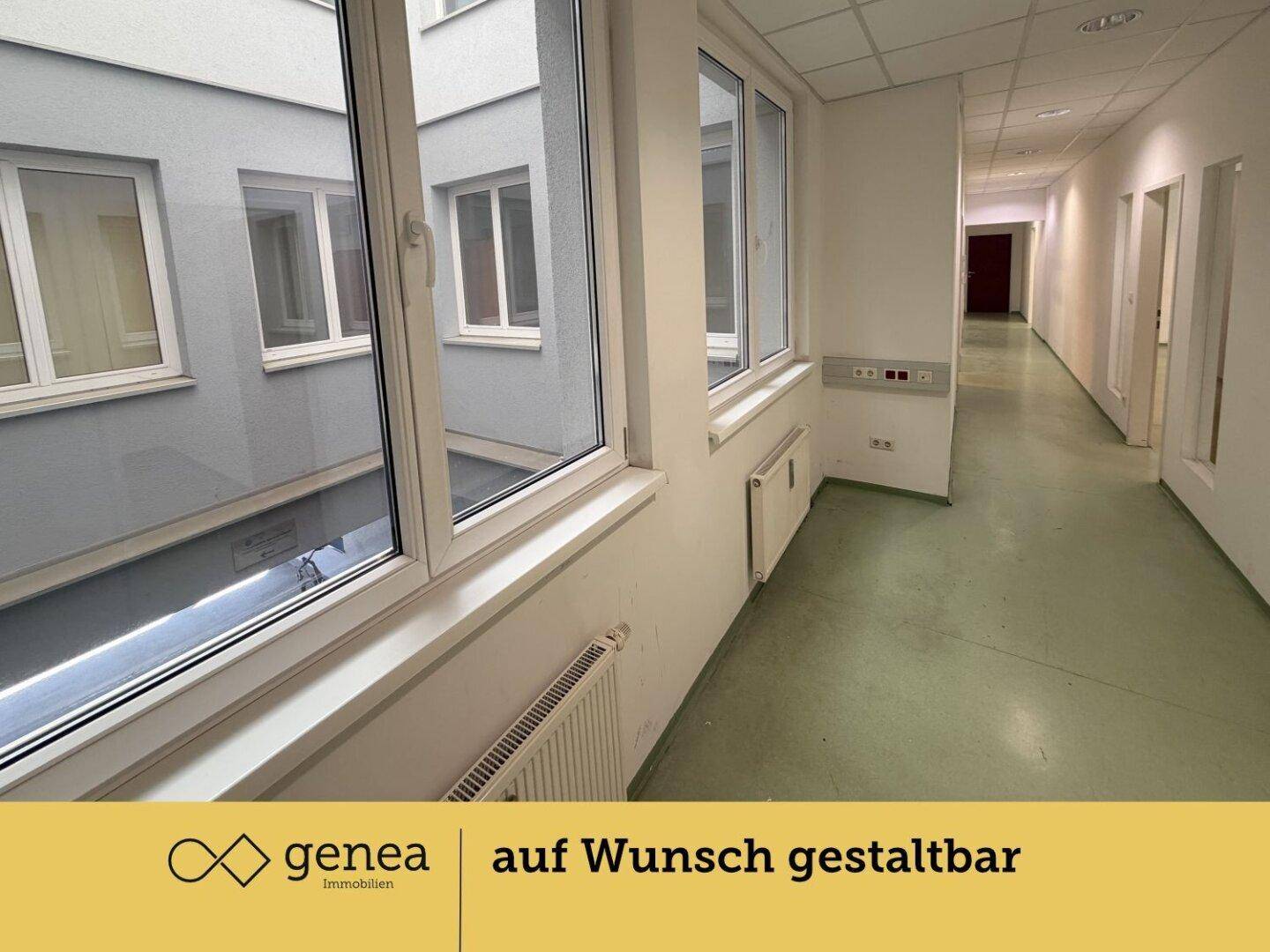 Heller Flur mit Fenstern zum Innenhof, der Zugang zu mehreren Büros bietet.