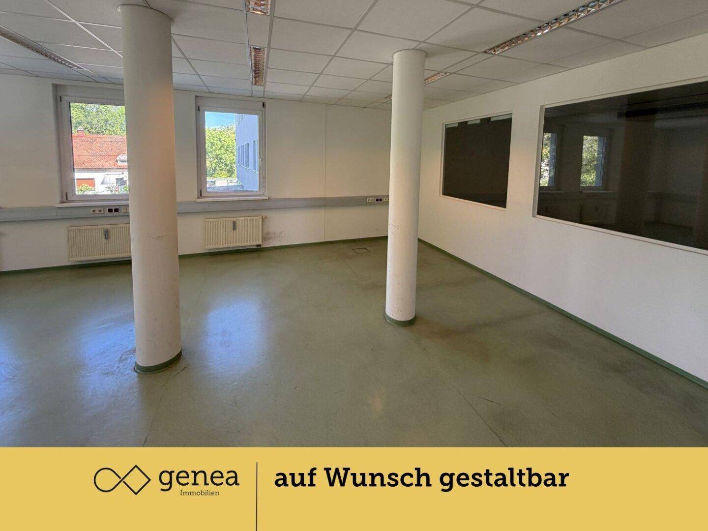 Großes Büro mit Säulen und Fenstern, die einen Blick nach draußen und in angrenzende Räume ermöglichen.