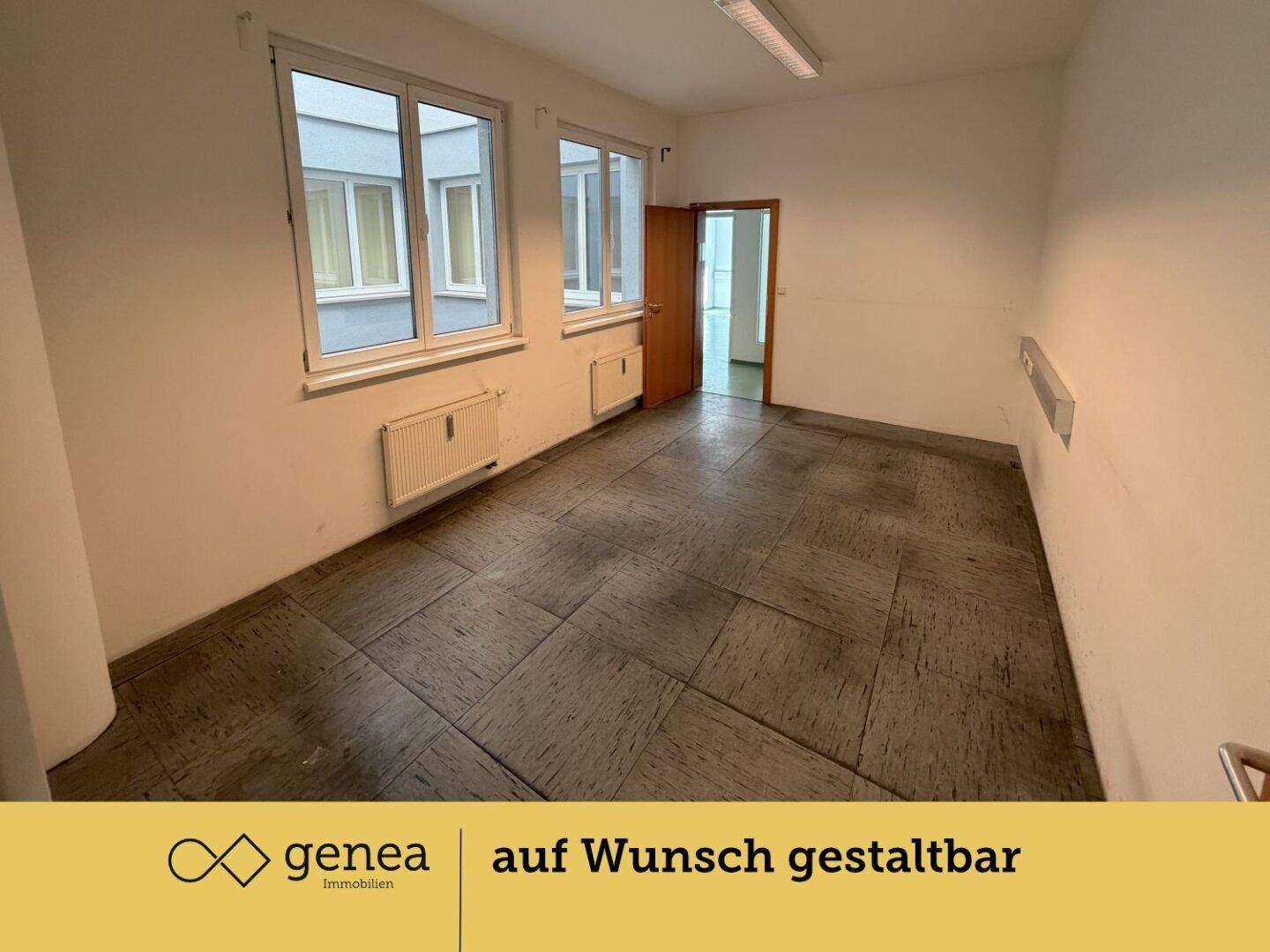 Büro mit Fenstern zum Innenhof und dunklem Fliesenboden, bietet eine ruhige Arbeitsumgebung.