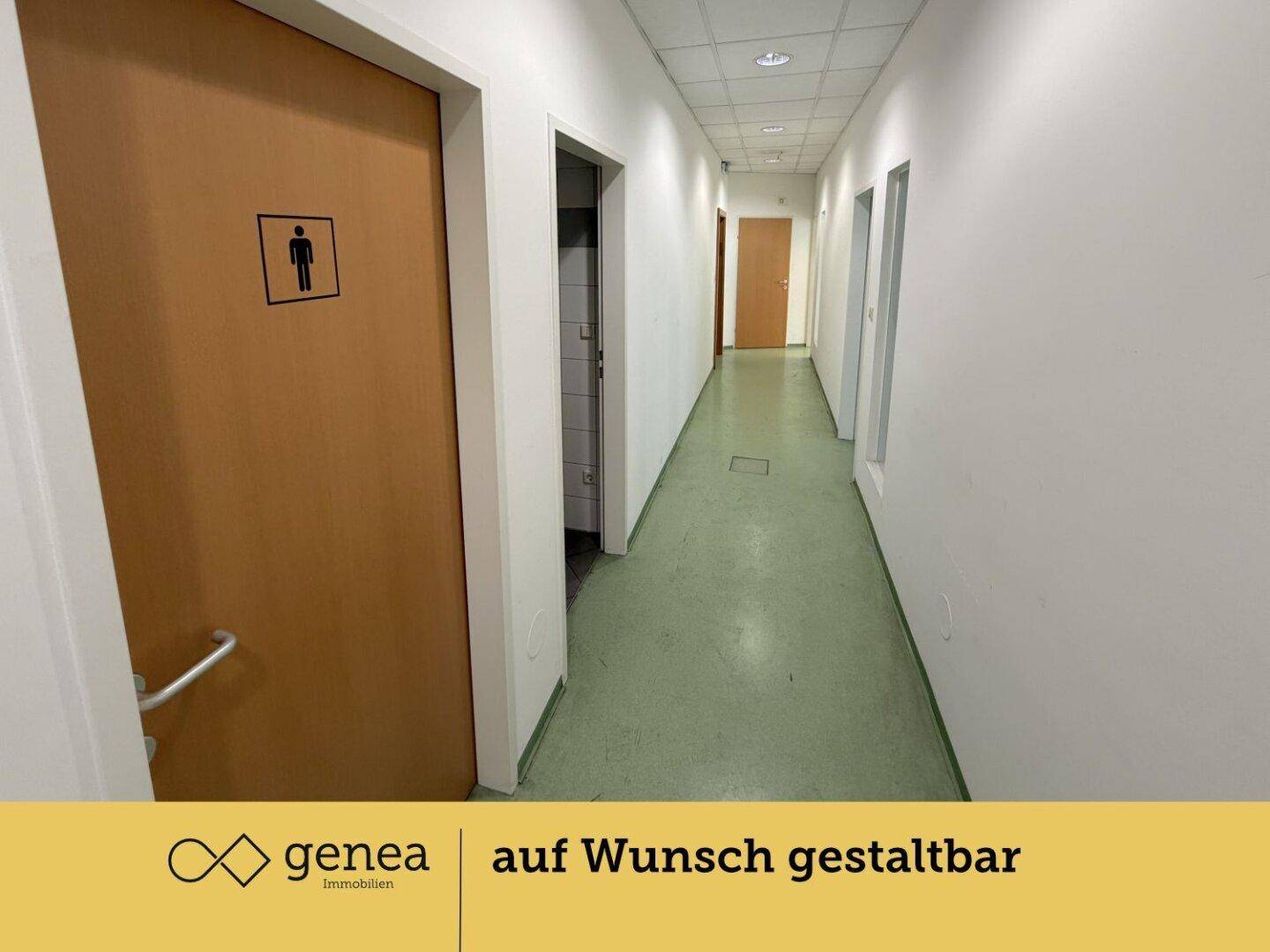 Langer Flur mit grünem Bodenbelag und Türen, eine davon mit Herren-Piktogramm.