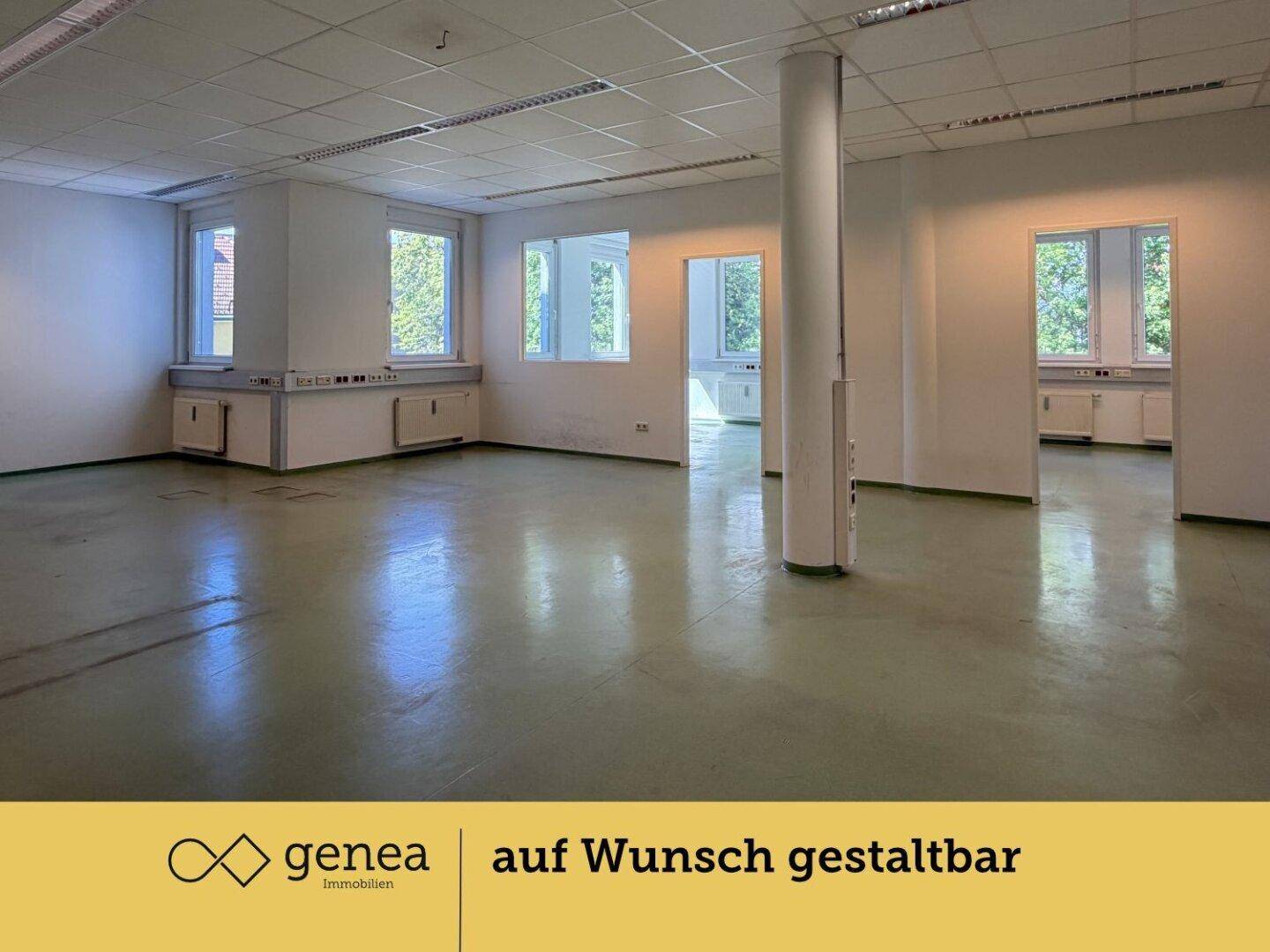 Großes, offenes Büro mit mehreren Fenstern, Säule und grünem Bodenbelag, vielseitig nutzbar.