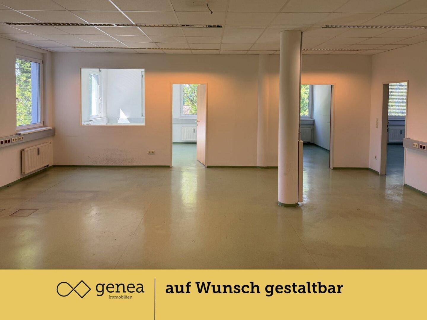 Großer, offener Bürobereich mit Säule, mehreren Fenstern und grünem Bodenbelag.