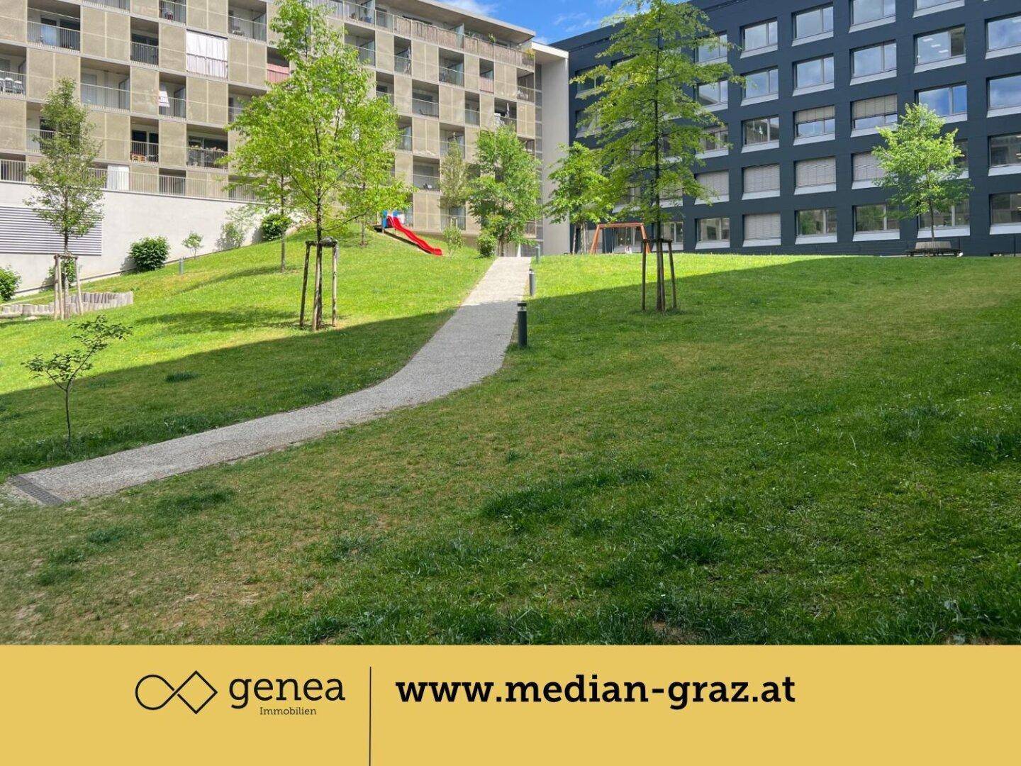 Weitläufige Rasenfläche im Innenhof mit Spazierwegen und einem kleinen Spielplatz, umgeben von Wohngebäuden.
