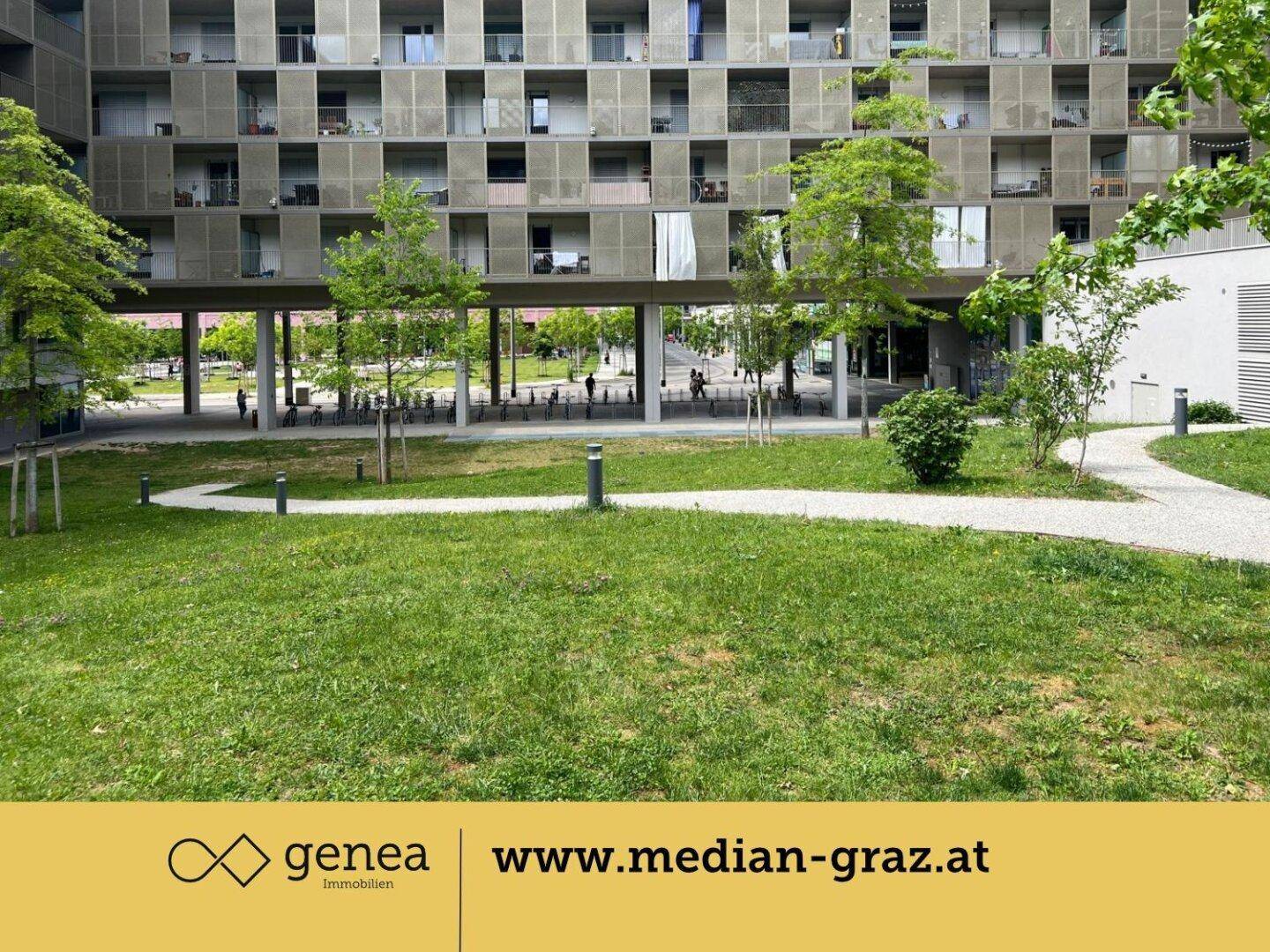 Offener Innenhofbereich mit Rasenflächen und Wegen, umgeben von der modernen Architektur des Wohnkomplexes.