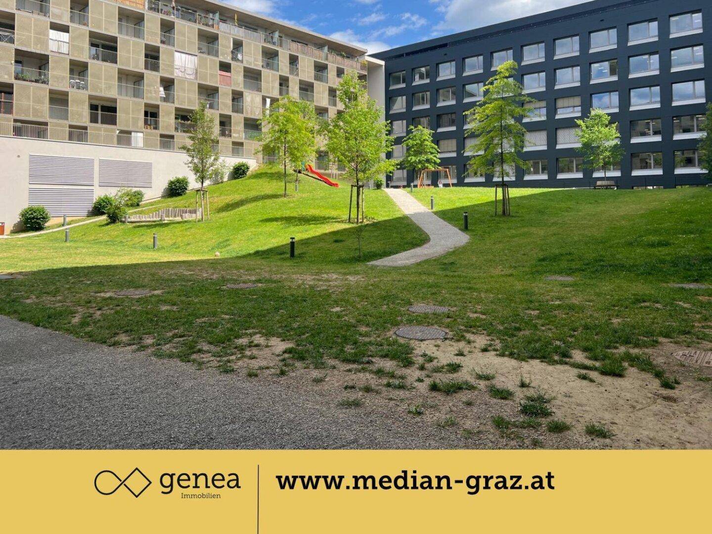 Grüne Außenanlage einer modernen Wohnanlage mit Rasenflächen, Bäumen und Kinderspielgeräten.