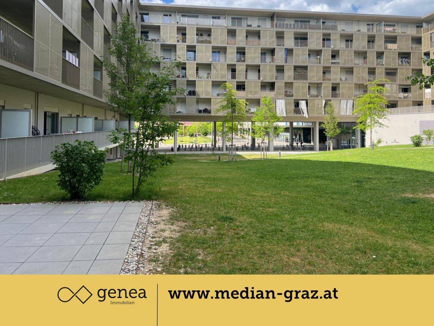 Gepflegter Innenhof mit Rasenfläche, Bäumen und einer kleinen Terrasse.