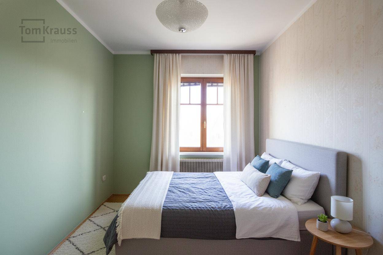 Modernes Schlafzimmer mit Bett, Nachttisch, grüner Akzentwand und Holzdielenboden.