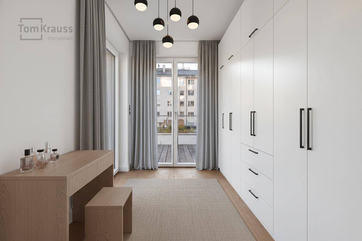 Elegantes Ankleidezimmer mit Einbauschränken, Schminktisch und französischem Balkon.