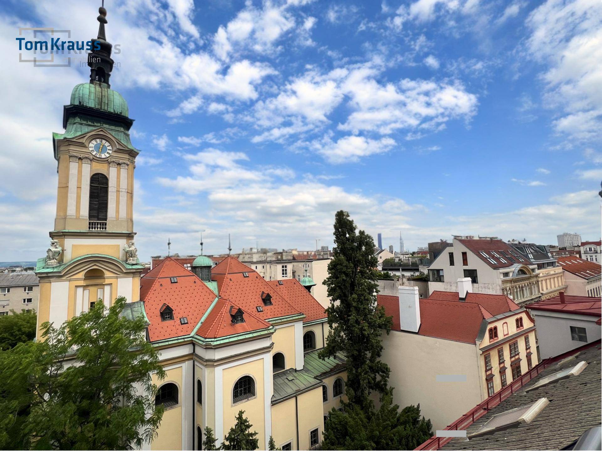 Panoramablick über die Stadt mit historischer Kirche und weitem Horizont unter blauem Himmel.