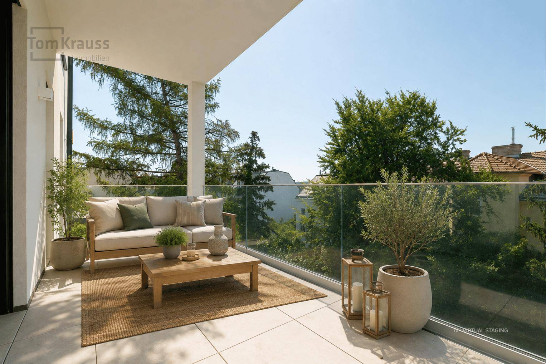 Gemütlicher Balkon mit Sitzgelegenheiten, Glasbrüstung und Blick auf grüne Bäume.