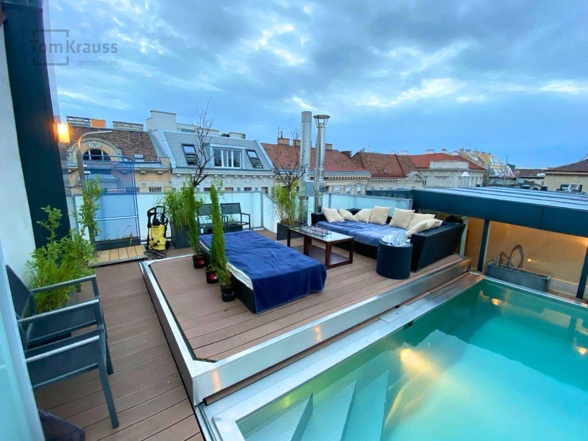 Abendliche Dachterrasse mit beleuchtetem Pool, Lounge-Möbeln und Blick über die Stadt.