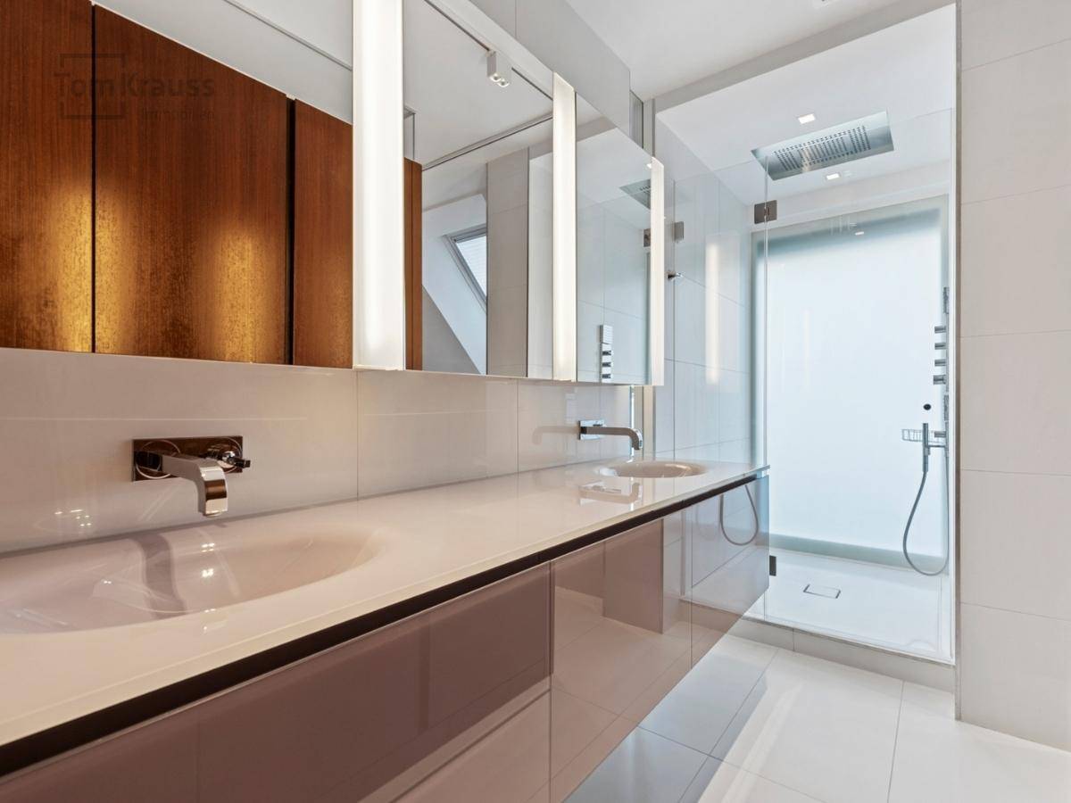 Modernes Badezimmer mit Doppelwaschbecken, großer Spiegelfront und begehbarer Dusche.