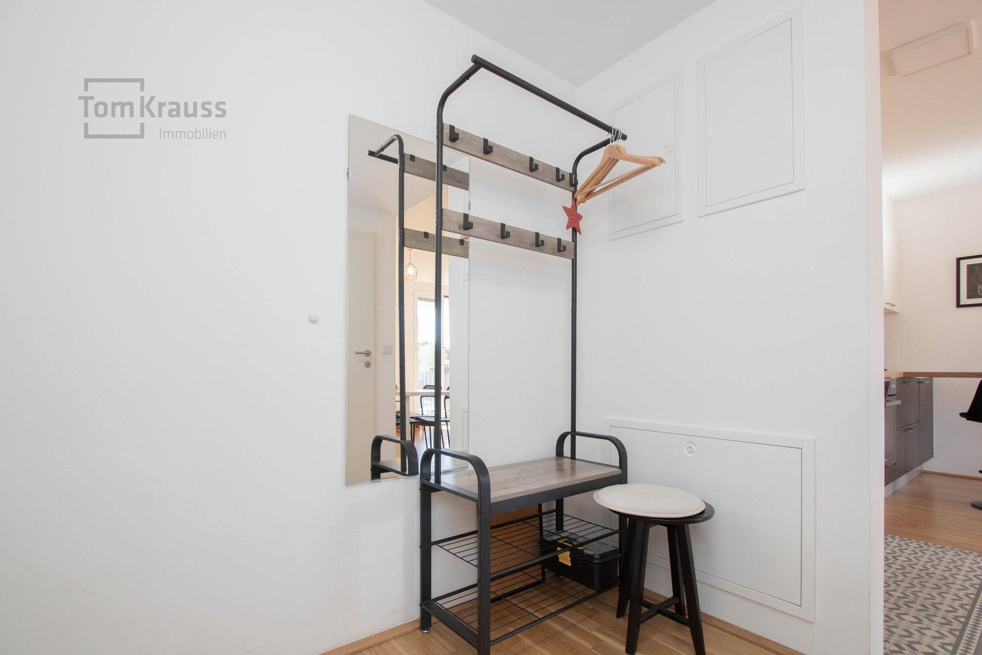 Eingangsbereich mit Garderobe und Spiegel, bietet praktischen Stauraum und Ablageflächen.
