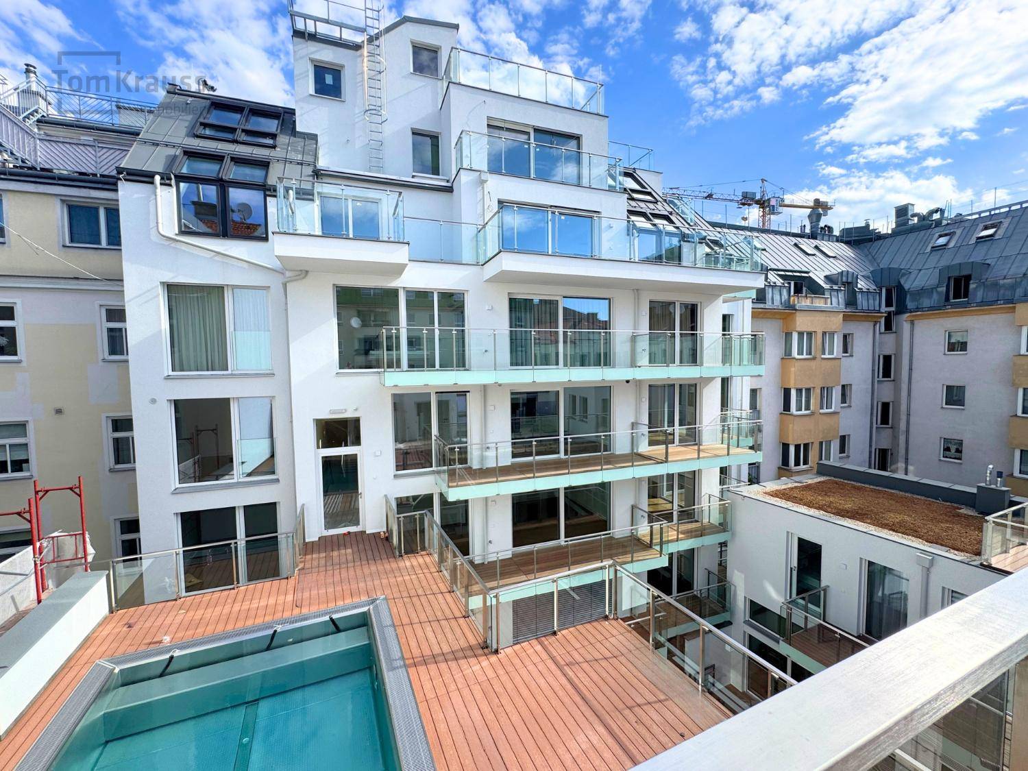 Dachterrasse mit Pool und Blick auf die umliegenden Gebäude und den Himmel.