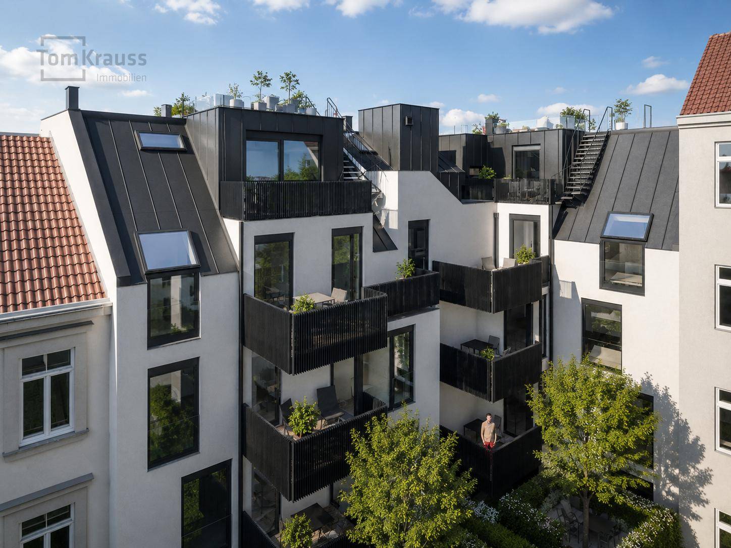 Rückansicht des modernen Gebäudes mit mehreren Balkonen und einem gepflegten Gartenbereich.