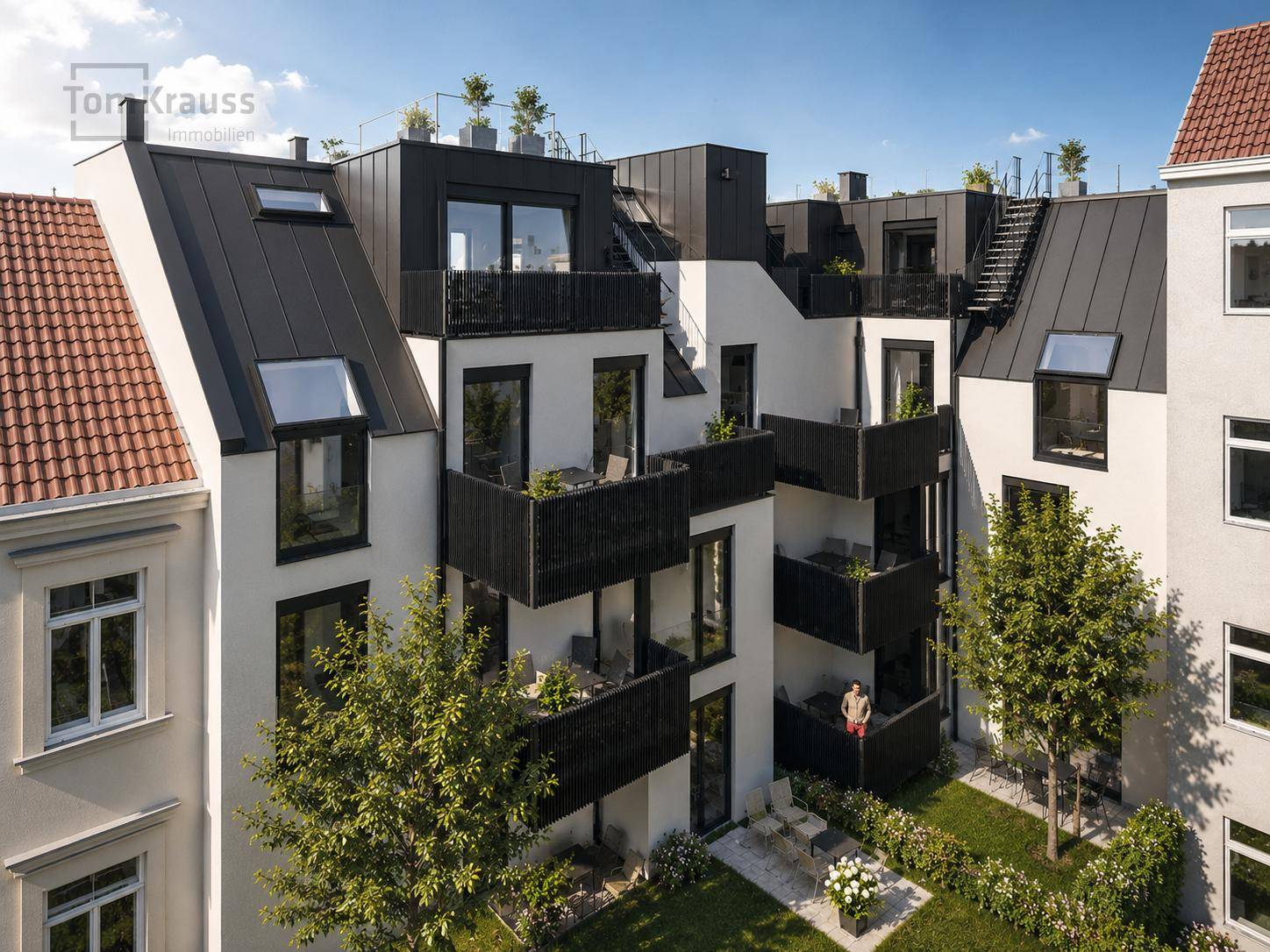 Moderne Wohnanlage von oben mit Balkonen, Dachterrassen und einem grünen Innenhof.