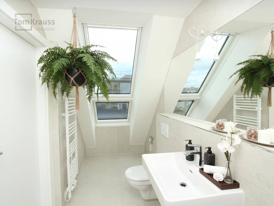 Modernes Badezimmer im Dachgeschoss mit schrägen Wänden, Dachfenstern und beheiztem Handtuchhalter.