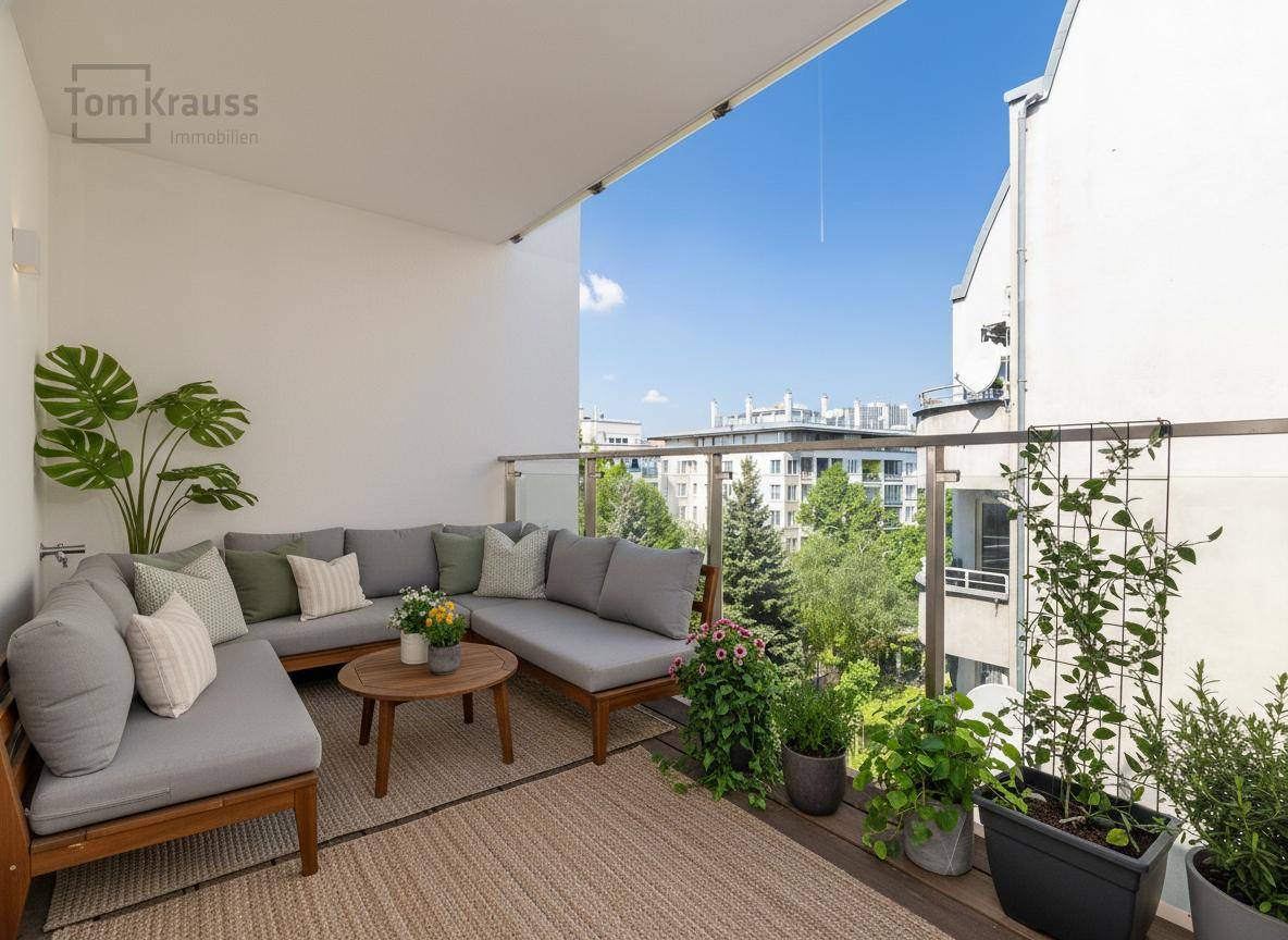 Gemütlicher Balkon mit bequemer Lounge-Ecke und Pflanzen, bietet einen angenehmen Ausblick ins Grüne.