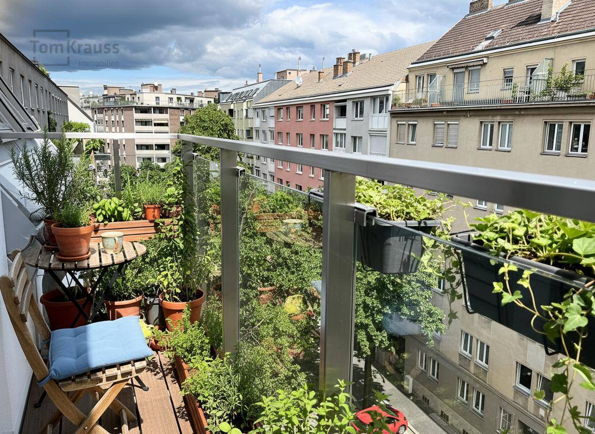 Begrünter Balkon mit vielen Pflanzen und Sitzgelegenheiten, bietet einen schönen Blick auf die Stadt.