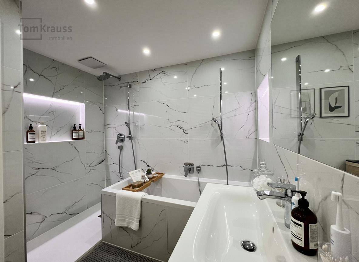 Modernes Badezimmer mit Badewanne, Dusche und eleganten Fliesen in Marmoroptik.